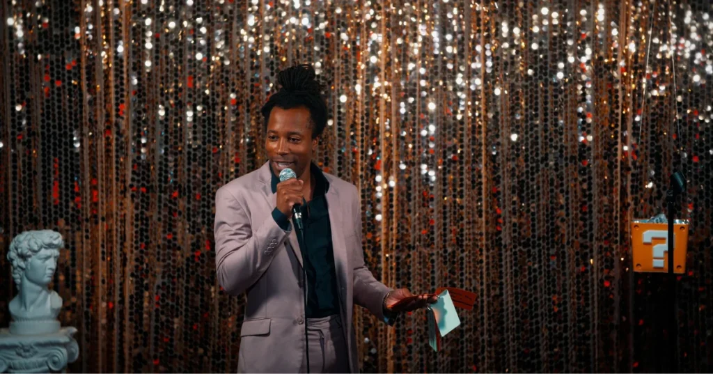 Chad Chambers emceeing an event with a microphone and cue card in hand