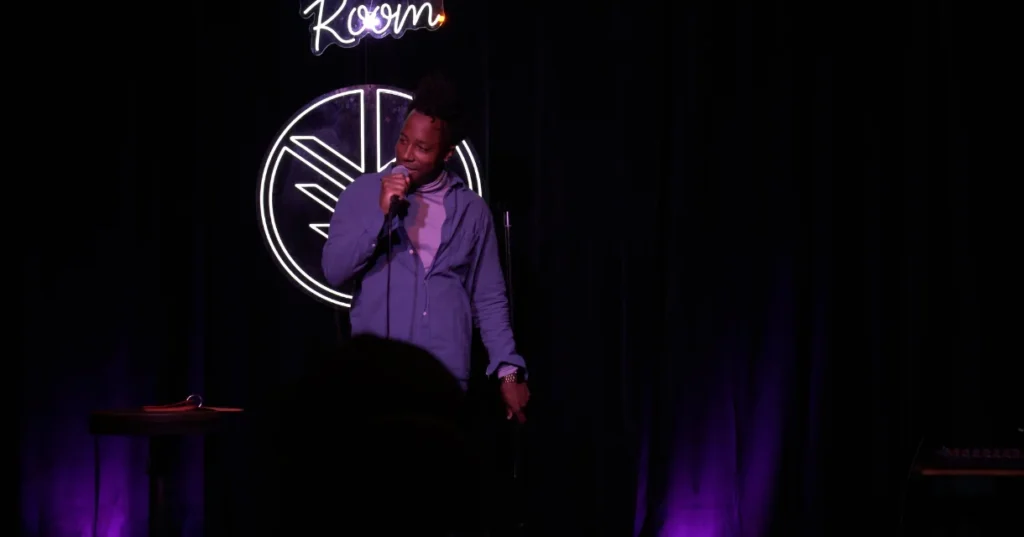 Chad Chambers performing stand-up on a purple-lit stage